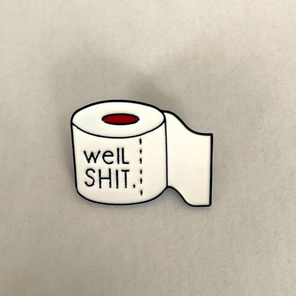 Jewelry - COPY - A pin with the words @ WELL SHIT” on a toilet paper roll